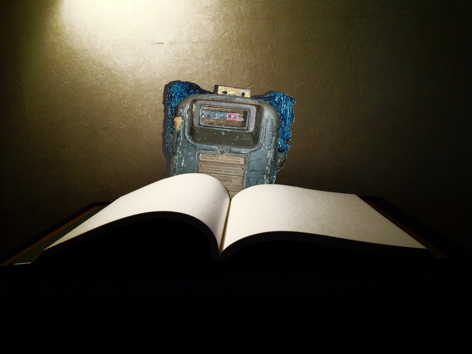 Livre ouvert aux pages blanches avec en arrière plan un compteur à gaz